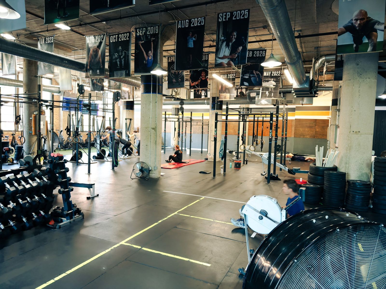 The main training floor at Windy City with rigs, rowers and Athlete of the Month banners hanging from the ceiling